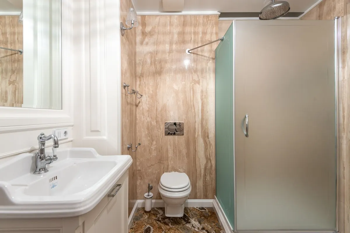 A bathroom with mirror lighting and a shower enclosure