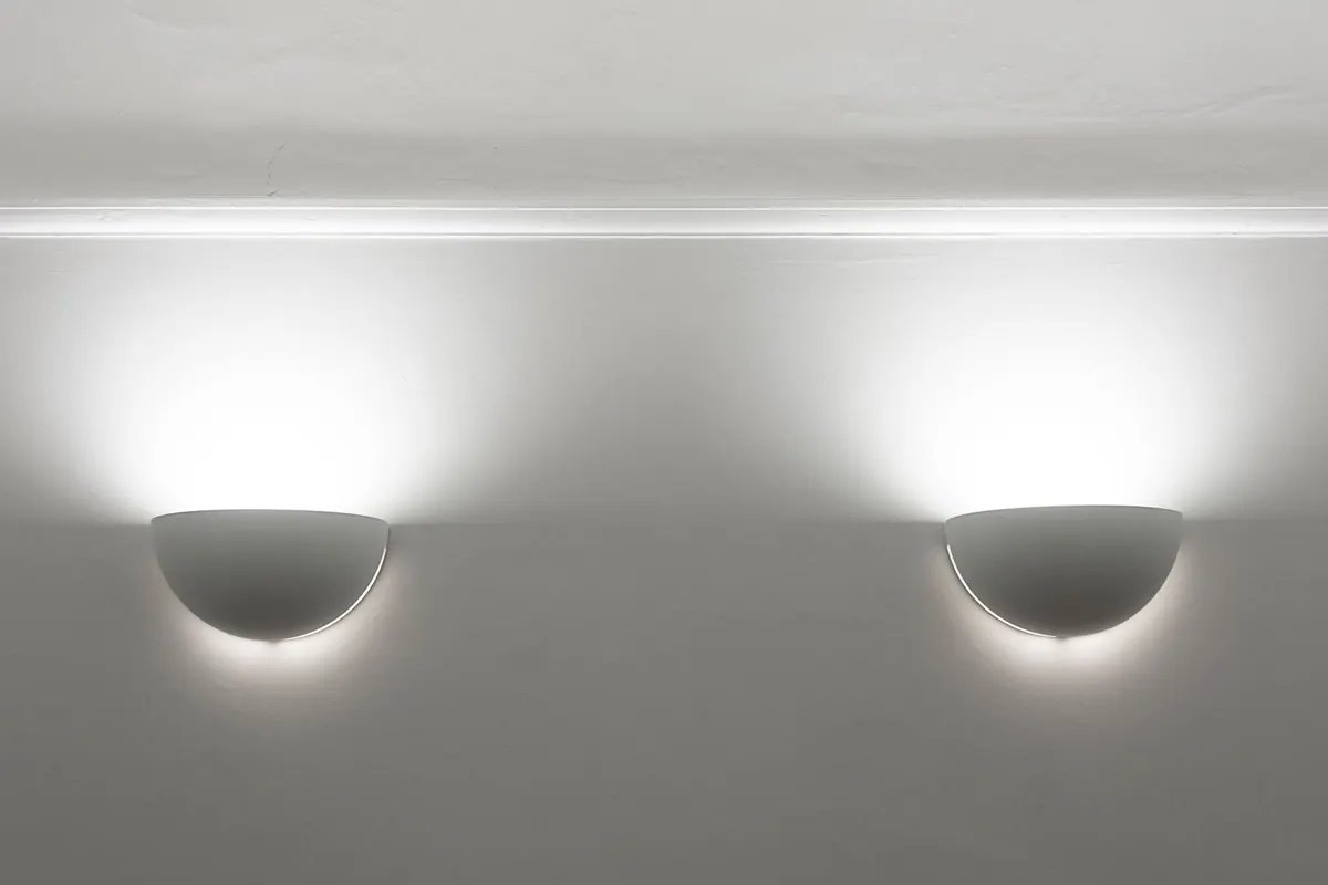 Two wall light fittings illuminating a white wall